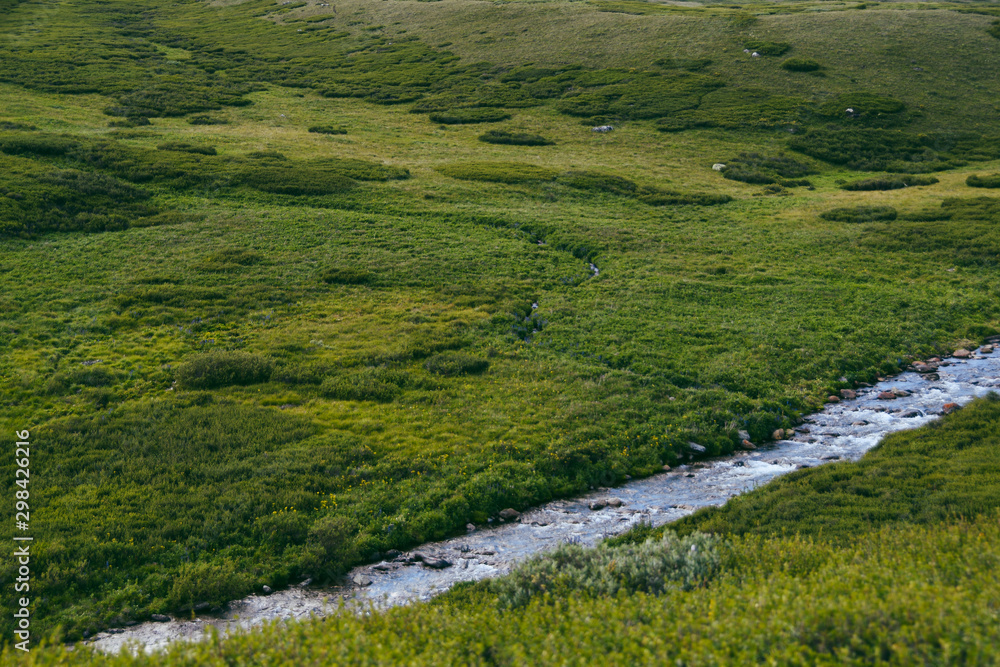 River in green hills. Swift stream in green meadow River in green hills. Swift stream in green meadow