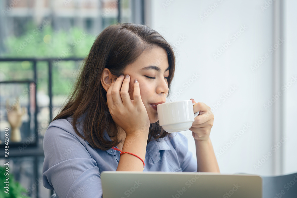 Happy Asian woman drinking hot coffee while working in cafe, lifestyle concept. Happy Asian woman drinking hot coffee while working in cafe, lifestyle concept.