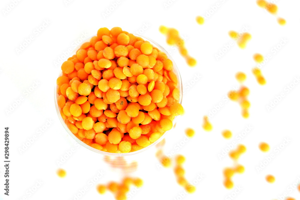 Fototapeta premium Red lentils on white background. Different forms of dry lentils. Lentils red in a transparent glass jar. Handful of legumes.