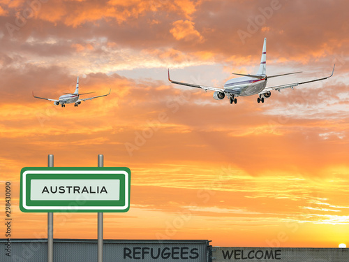 Digital composite and 3D illustration of two passenger jet airliners flying into a beautiful red sunset sky with a sign of Australia and refugees welcomed on a wall in the foreground   
