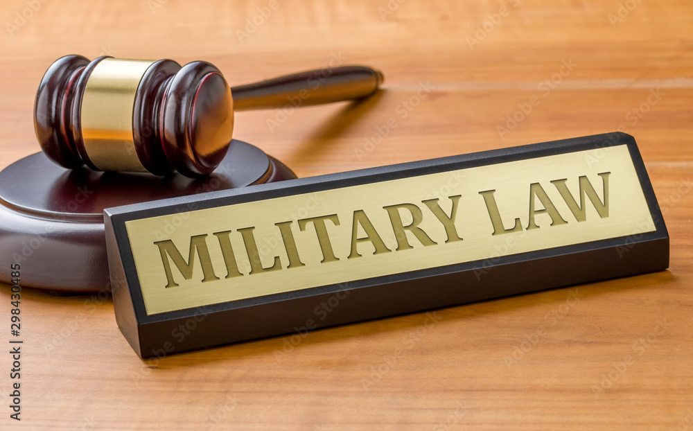A gavel and a name plate with the engraving Military law A gavel and a name plate with the engraving Military law