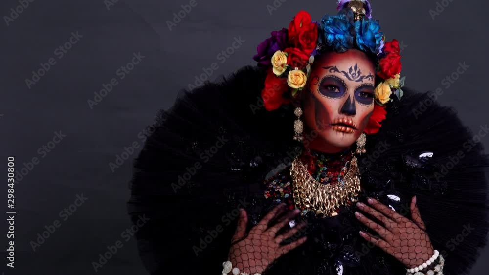 Closeup portrait of a woman with a skull makeup dressed with flower crown. Closeup portrait of a woman with a skull makeup dressed with flower crown.
