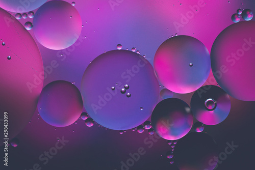 Water and oil, beautiful color abstract background based on blue, neon, purple and pink circles, macro abstraction.