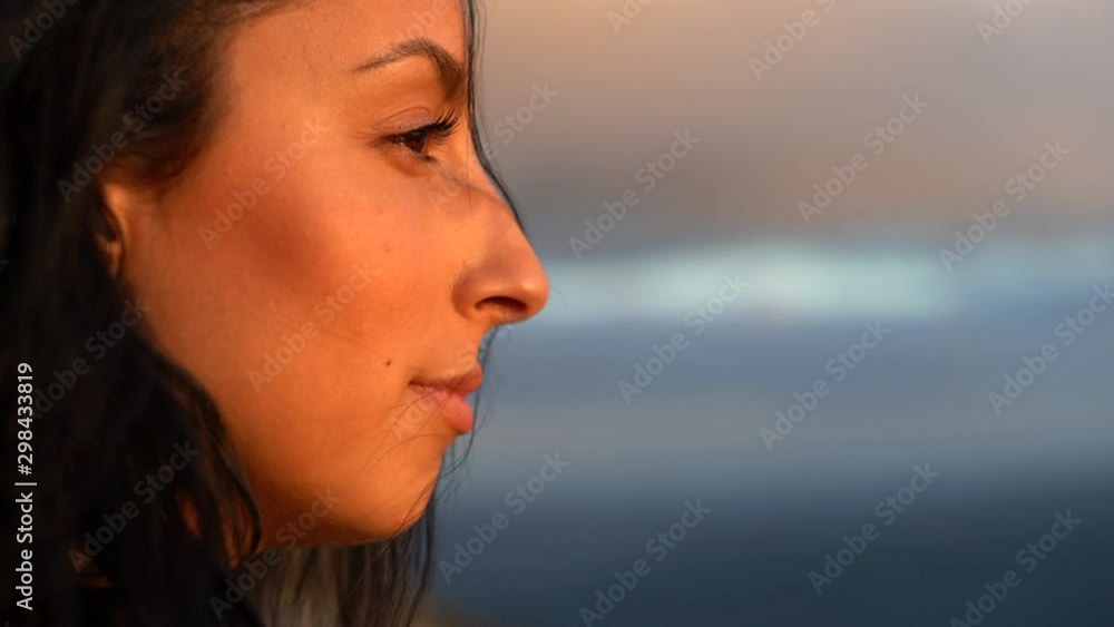 Confident, happy and serene young woman enjoys a moment looking over the scenery below - portrait close up slowmo Confident, happy and serene young woman enjoys a moment looking over the scenery below - portrait close up slowmo