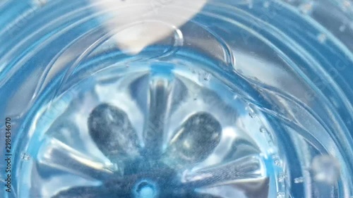 Pure water in a bottle of blue color. Water soda in a blue plastic bottle close up with small bubbles