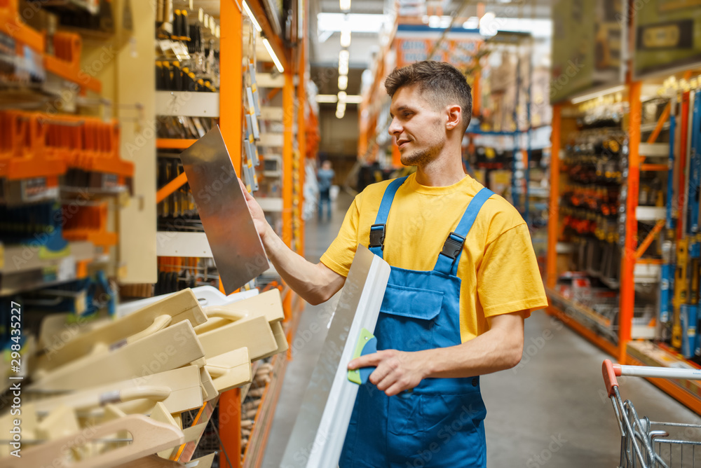 Builder choosing screed level in hardware store Builder choosing screed level in hardware store