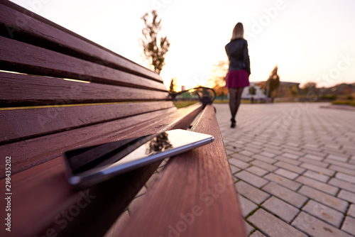Slika na platnu Forgotten smartphone on a park bench.