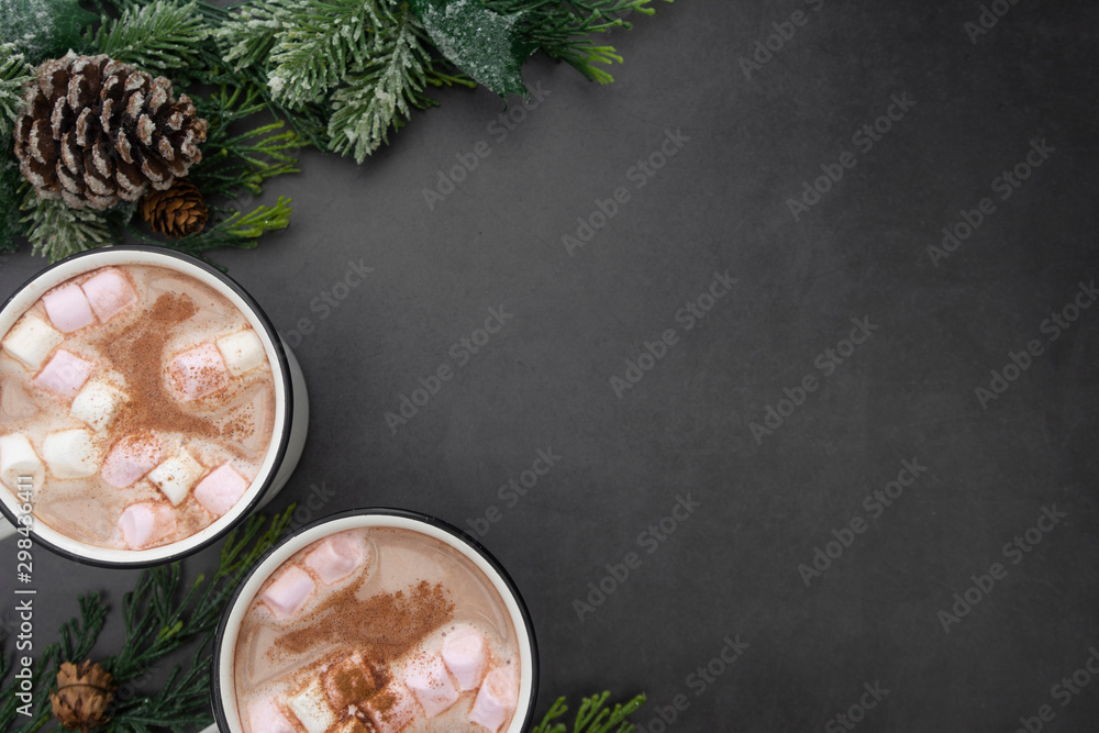 Hot chocolate mugs with marshmallows. Flat lay with fir branches. Gray background. Warm winter drink. Hot chocolate mugs with marshmallows. Flat lay with fir branches. Gray background. Warm winter drink.