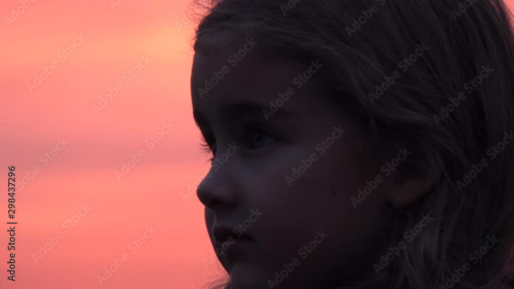 Kid looking up at the sky in nature. Little girl praying looking up at purple sky with hope, close-up. Kid looking up at the sky in nature. Little girl praying looking up at purple sky with hope, close-up.