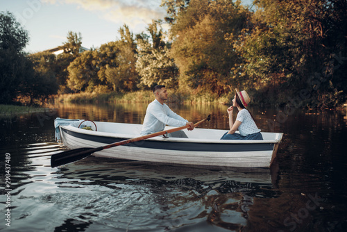 Fotografie Love couple boating on lake, water reflection