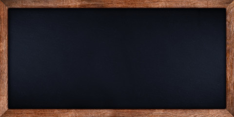 wide panorama dark stone slate blackboard or chalkboard with rustic wooden oak wood frame empty copy space. school education study concept background.