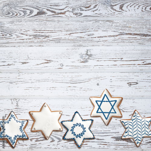 Star shaped cookies on wooden background with Hanukkah menorah and Star of David photo