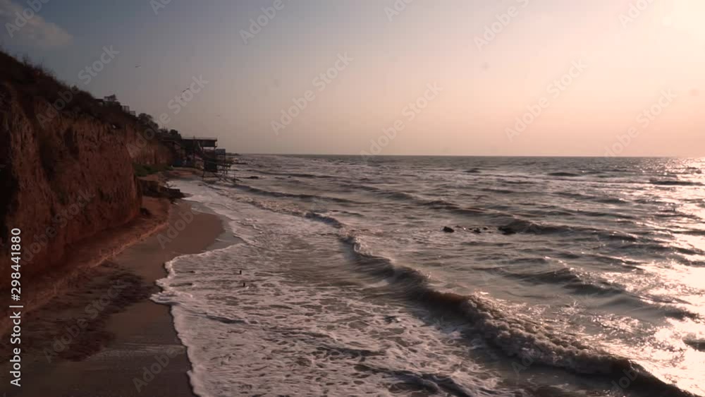 purple and pink sunset view on the beach with sandy clay breakage and slow shutter speed sea waves and rocks seascape with breakage zen scene on the beach purple and pink sunset view on the beach with sandy clay breakage and slow shutter speed sea waves and rocks seascape with breakage zen scene on the beach