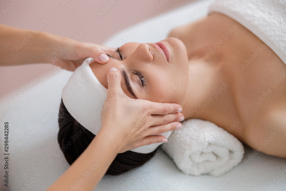 Relaxed young woman having therapeutic face massage - obrazy, fototapety, plakaty 