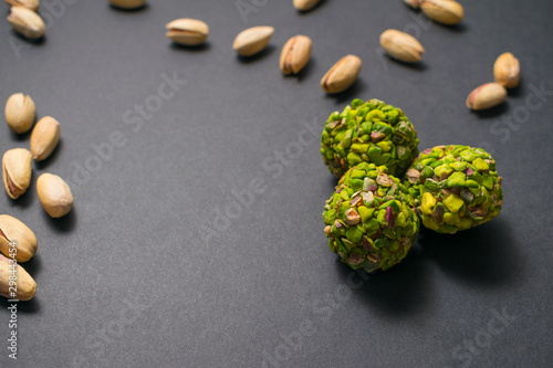 Three turkish pistachio candies. Healthy food. Scattered pistachio nuts. Top view. Copy space.