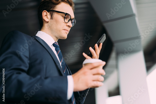 Serious ceo with cell phone and coffee indoors stock photo