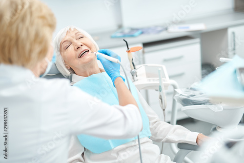 Gray-haired elderly woman at the dentist appointment