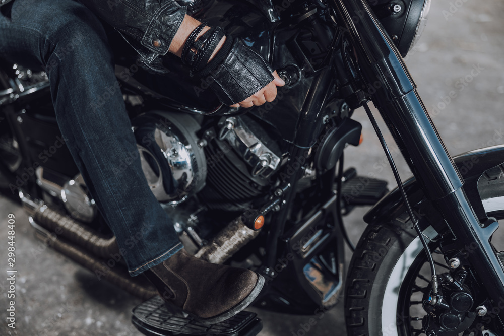 Male biker sitting on modern black motorcycle Male biker sitting on modern black motorcycle