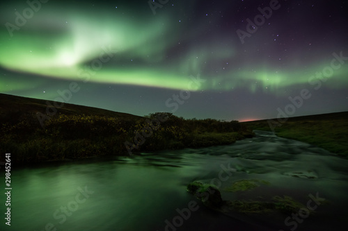 Northern lights with reflection in river  North Iceland