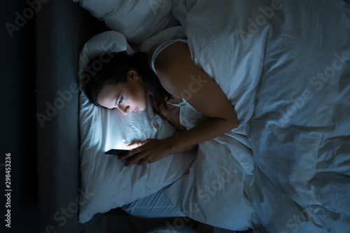 Woman In Bed With Mobile Phone