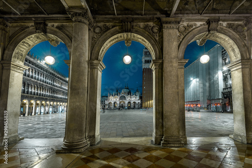 Venice at night, Italy. View to old St Mark`s Square or San Marco. It is a top tourist attraction of Venice. Vintage architecture of Venice at dusk. Scenery of famous Venice city center in evening. photo