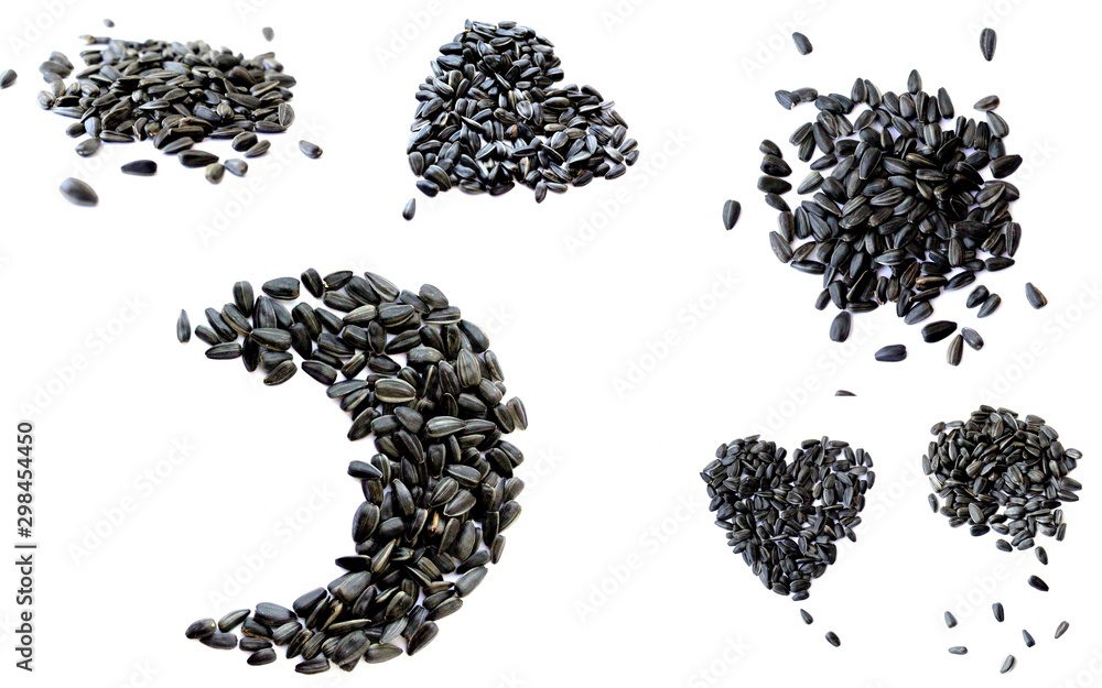 Black small sunflower seeds. Seeds in the shape of a heart and a month. Handful of seeds.