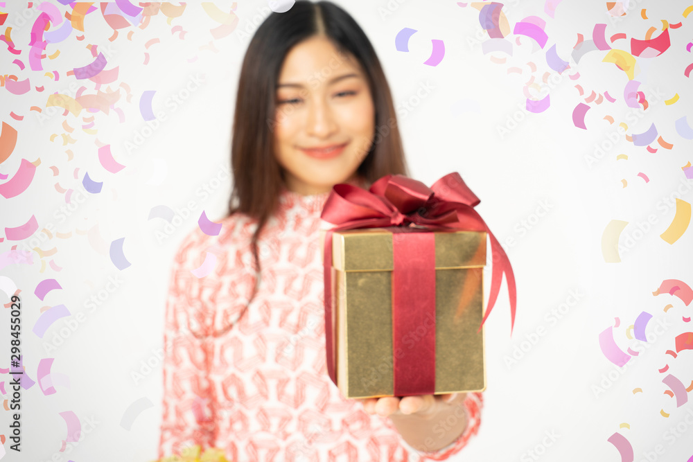 Photo of asian curious woman in red dress rejoicing her birthday or new year gift box. Young woman holding gift box with red bow being excited and surprised holiday present isolated white background Photo of asian curious woman in red dress rejoicing her birthday or new year gift box. Young woman holding gift box with red bow being excited and surprised holiday present isolated white background