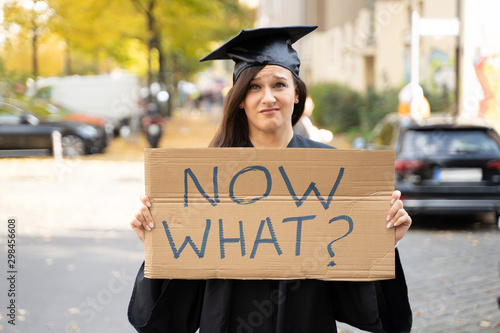 Sad Graduate Student Standing With Now What Placard