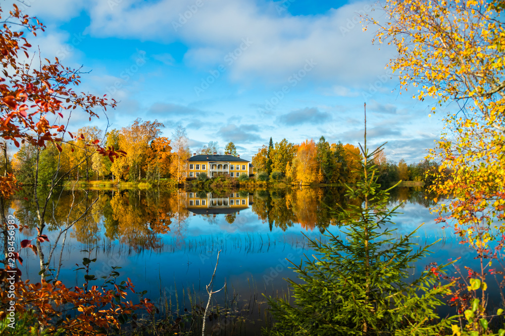 Kouvola, Finland - 8 October 2019: Autumn landscape with beautiful wooden Rabbelugn Manor - Takamaan Kartano. Wrede family house was built in 1820 on the river Kymijoki bank. Kouvola, Finland - 8 October 2019: Autumn landscape with beautiful wooden Rabbelugn Manor - Takamaan Kartano. Wrede family house was built in 1820 on the river Kymijoki bank.