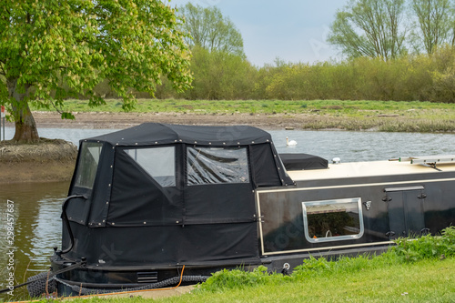 Moored narrow boat seen on an inland waterway during late spring. One of a number of narrow boats used for hire and also private owners.