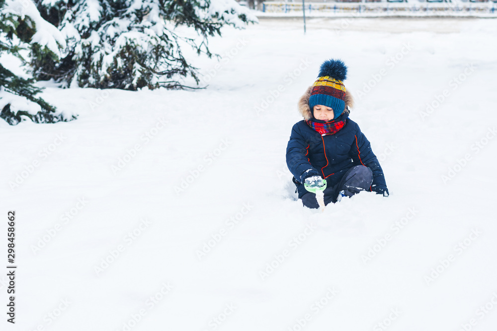boy with a shovel playing outside in the snow boy with a shovel playing outside in the snow