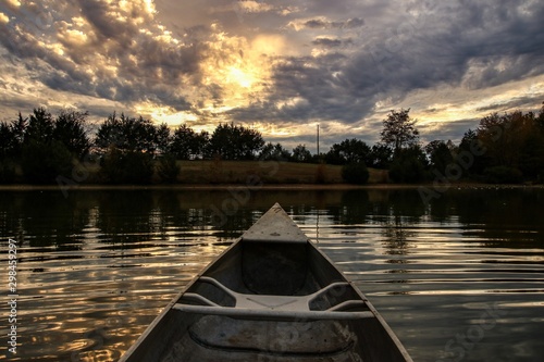 Point of view of a canoeist paddling on a serene country pond at sunset