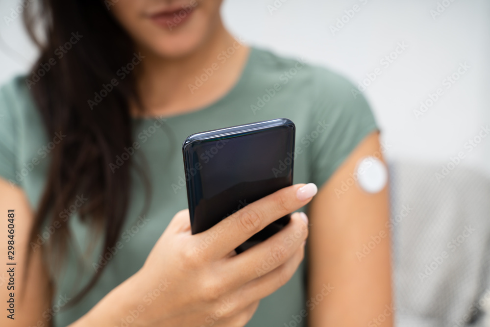 Woman Checking Blood Sugar Level On Smart Phone