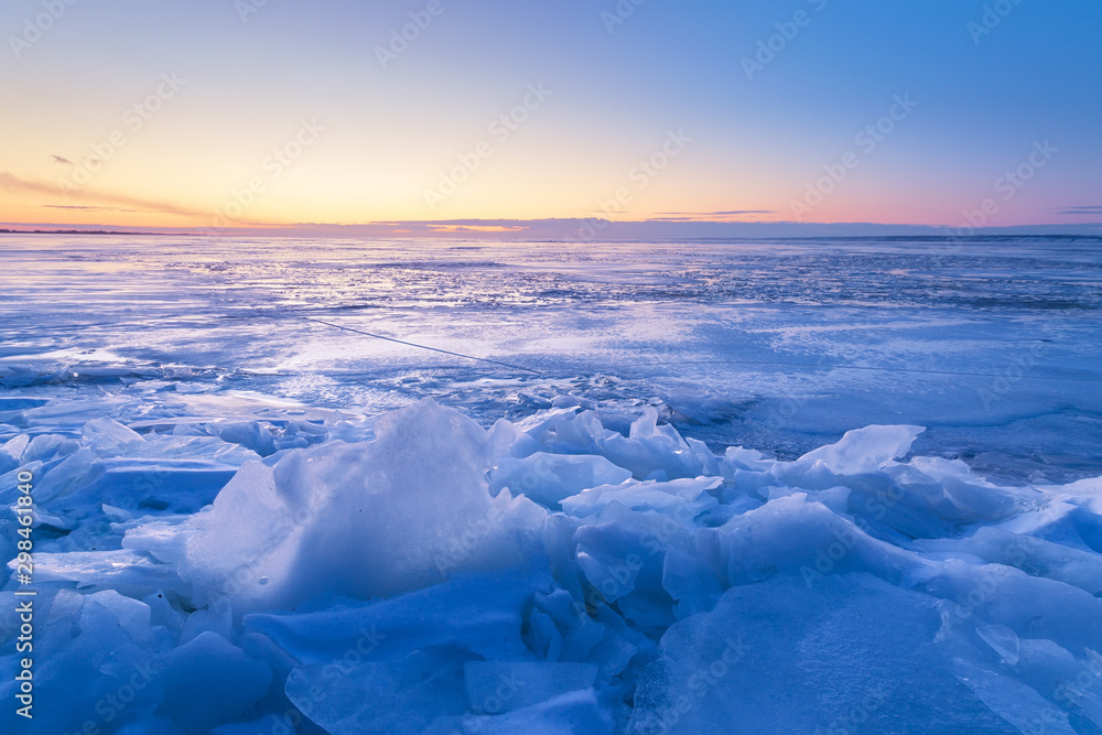 Obraz premium misty dawn on a frozen river / sun breaks through morning fine snow