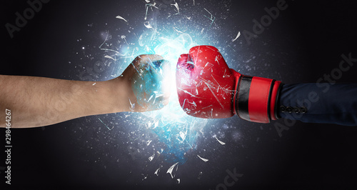 Two hands fighting and breaking glass into small pieces with blue light concept © ra2 studio