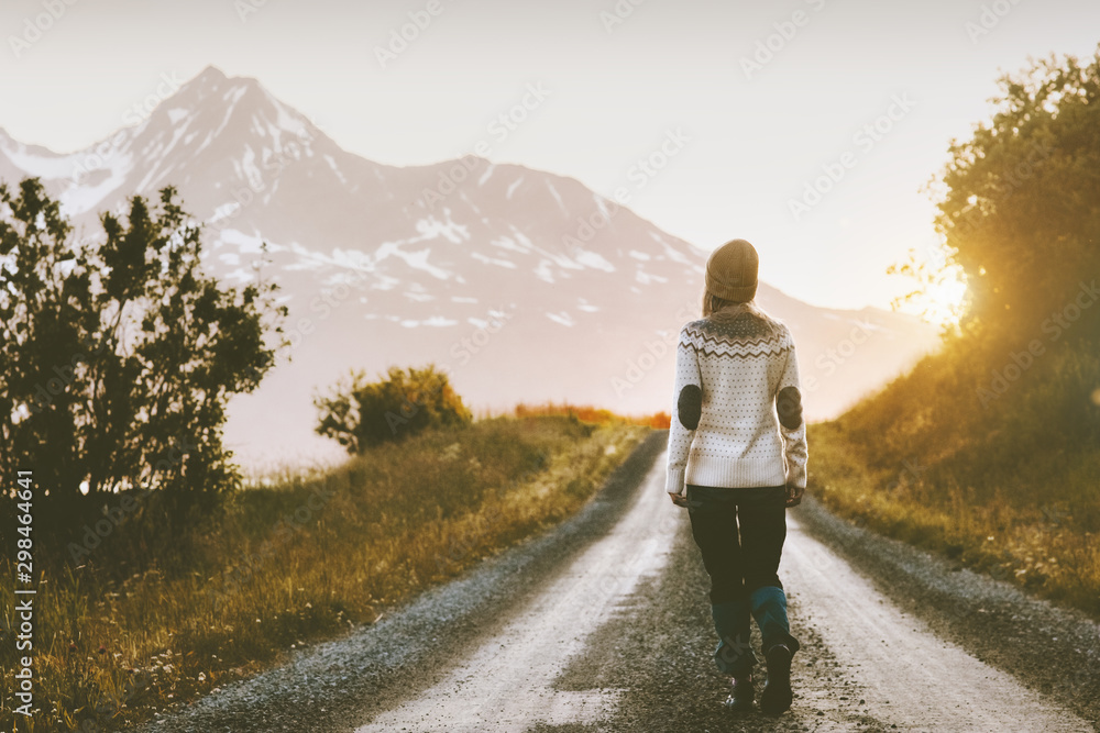 Woman walking alone on gravel road in mountains Travel lifestyle adventure vacations escape outdoor - obrazy, fototapety, plakaty 