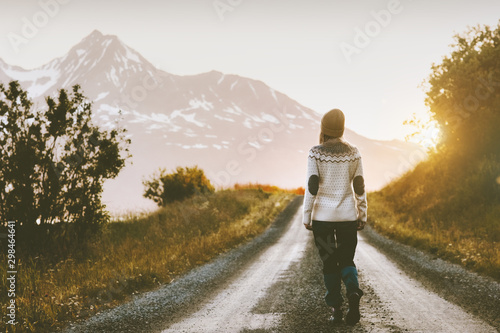 Woman walking alone on gravel road in mountains Travel lifestyle adventure vacations escape outdoor