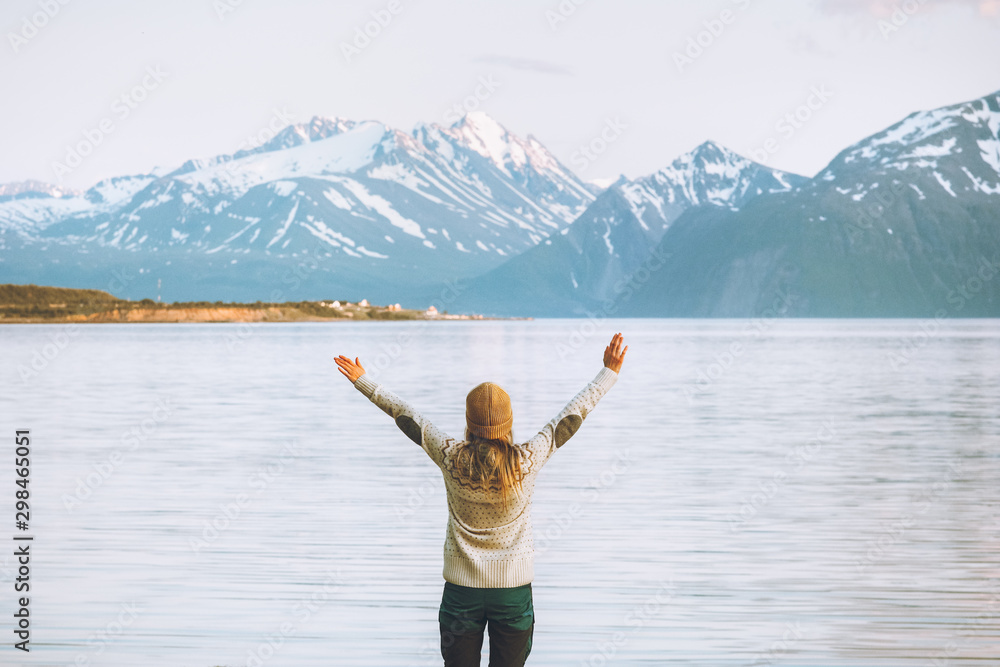 Traveler woman raised hands enjoying mountains view travel adventure vacations in Norway healthy lifestyle Lyngen Alps landscape