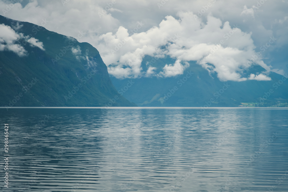 Dramatic dark thunderclouds over mountains and fjord in norway, travel to scandinavia. The beauty of northern nature