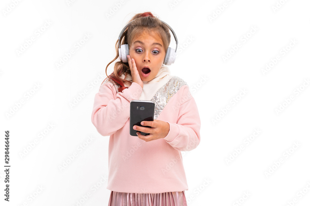 Little happy girl with headphones chatting with friends and is shocked Little happy girl with headphones chatting with friends and is shocked