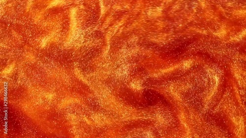 orange liquid with dye and sparkles. abstract moving background