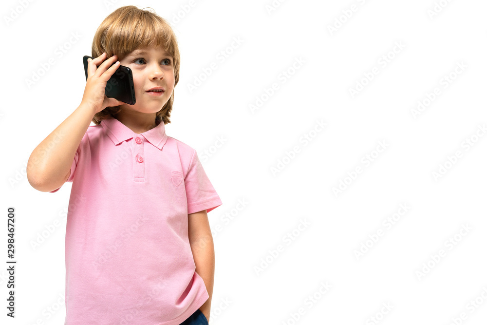 Little caucasian boy with pink t-shirt calls a phone isolated on white background Little caucasian boy with pink t-shirt calls a phone isolated on white background