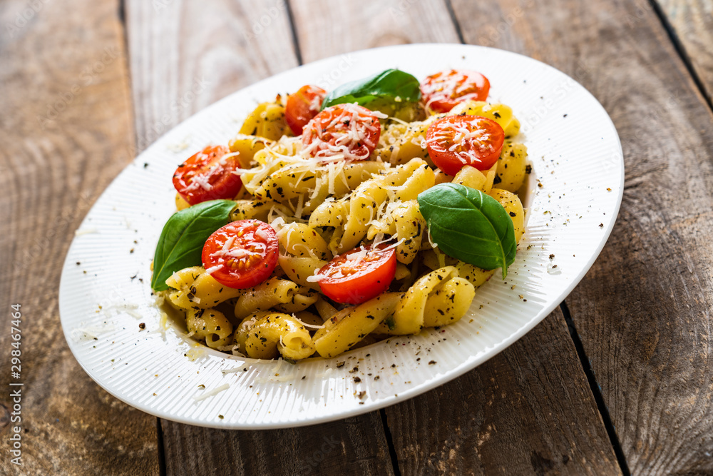 Pasta with cherry tomatoes and cheese on wooden table Pasta with cherry tomatoes and cheese on wooden table