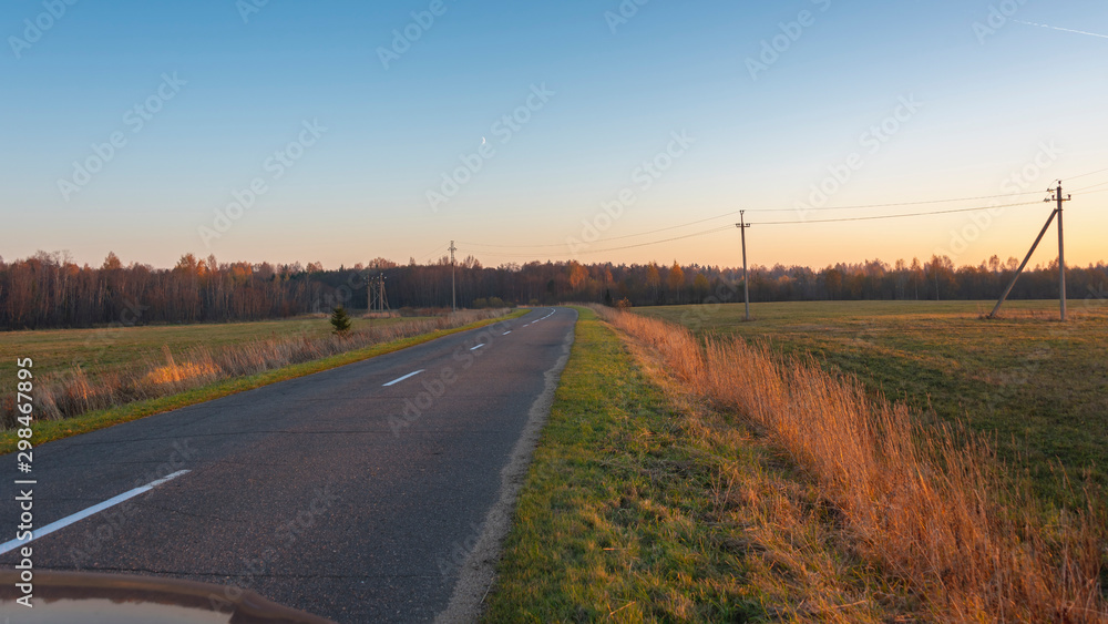 Suburban road goes into the distance at sunset Suburban road goes into the distance at sunset