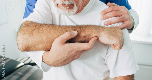 Foto Senior patient while exercise treatment with his physiotherapist