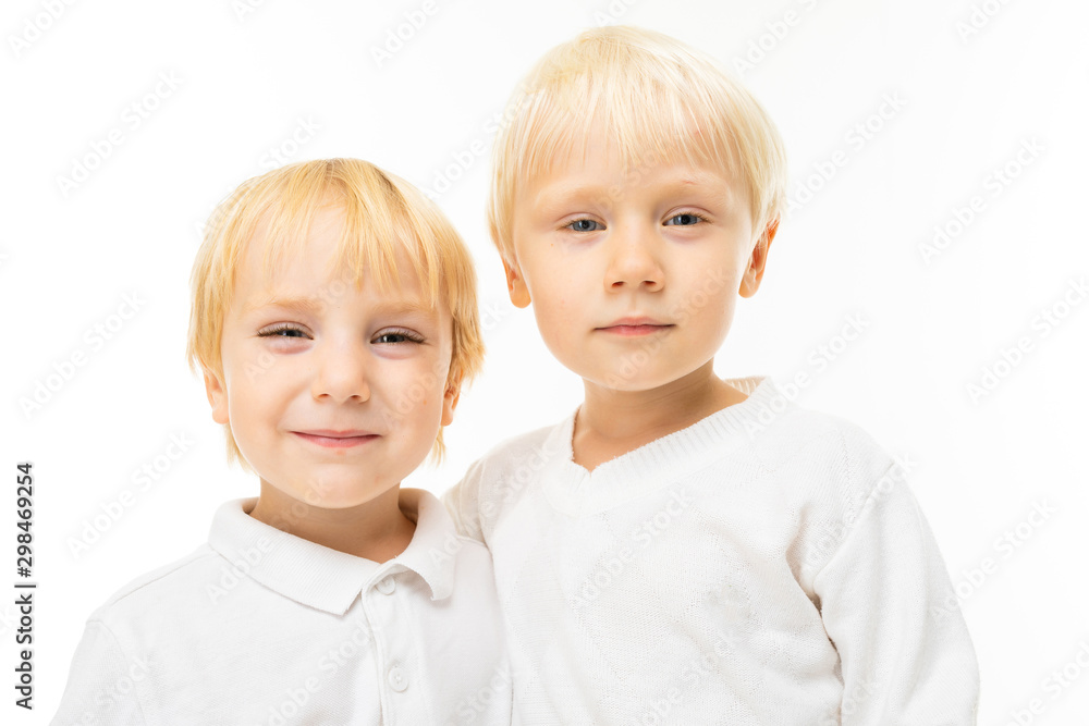 Little boys brothers with short light and red hair, blue eyes, cute appearance, in white jacket, light blue pants, stand and pose beautifully on camera Little boys brothers with short light and red hair, blue eyes, cute appearance, in white jacket, light blue pants, stand and pose beautifully on camera
