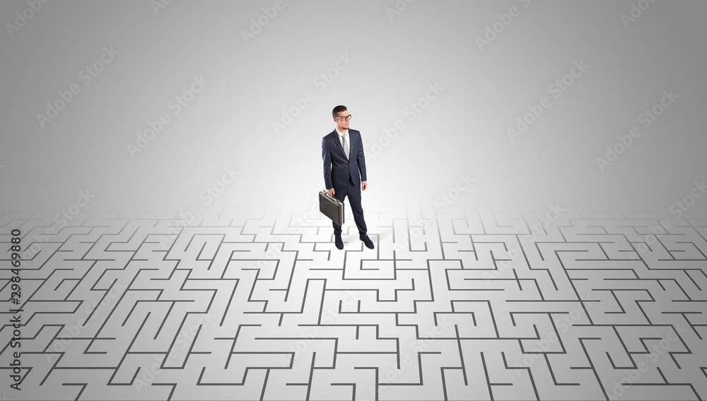 Elegant businessman looking for a solution in a middle of a maze Elegant businessman looking for a solution in a middle of a maze