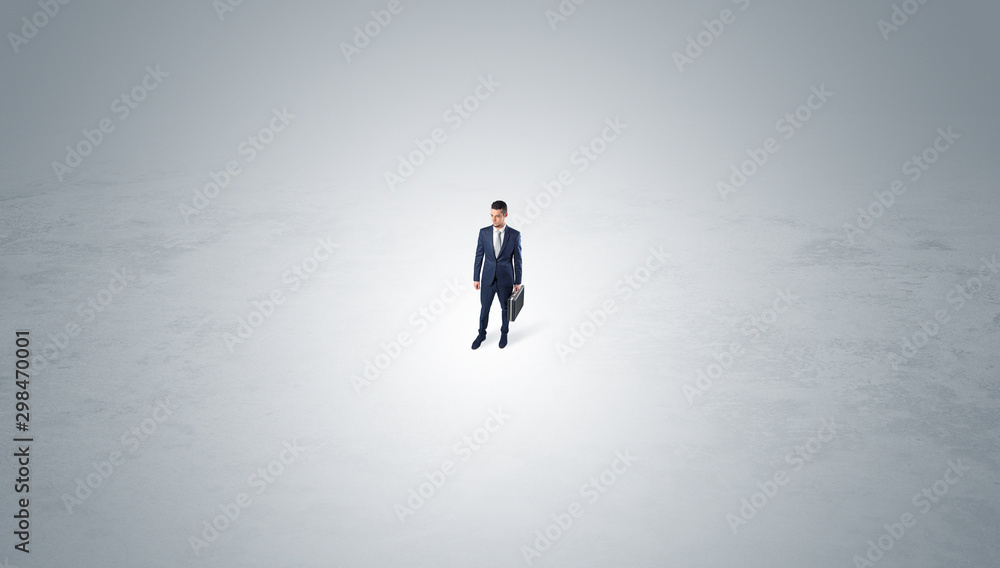Young businessman standing alone in the middle of an empty space Young businessman standing alone in the middle of an empty space