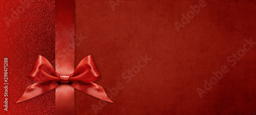 gift card wishes merry christmas background with red ribbon bow on red shiny vibrant color texture template with blank copy space