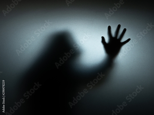 The scary black shadow is behind the glass. Halloween concept.